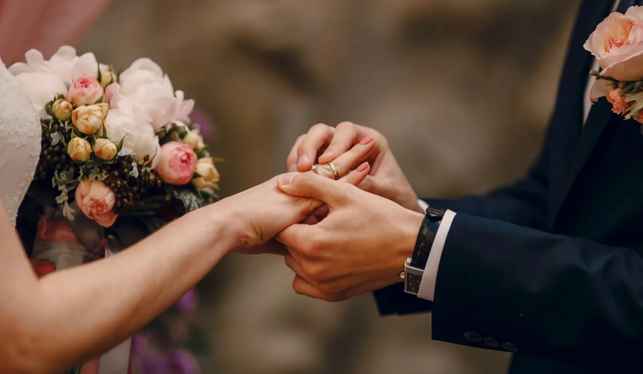 noivo colocando aliança em mão de noiva