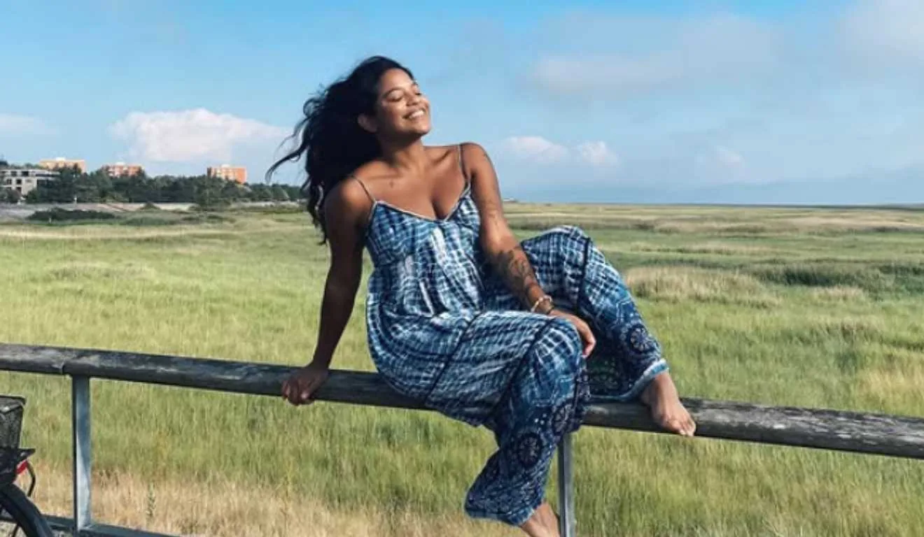 Juliana Marins, jovem morta em vulcão, sentada em corrimão no mato