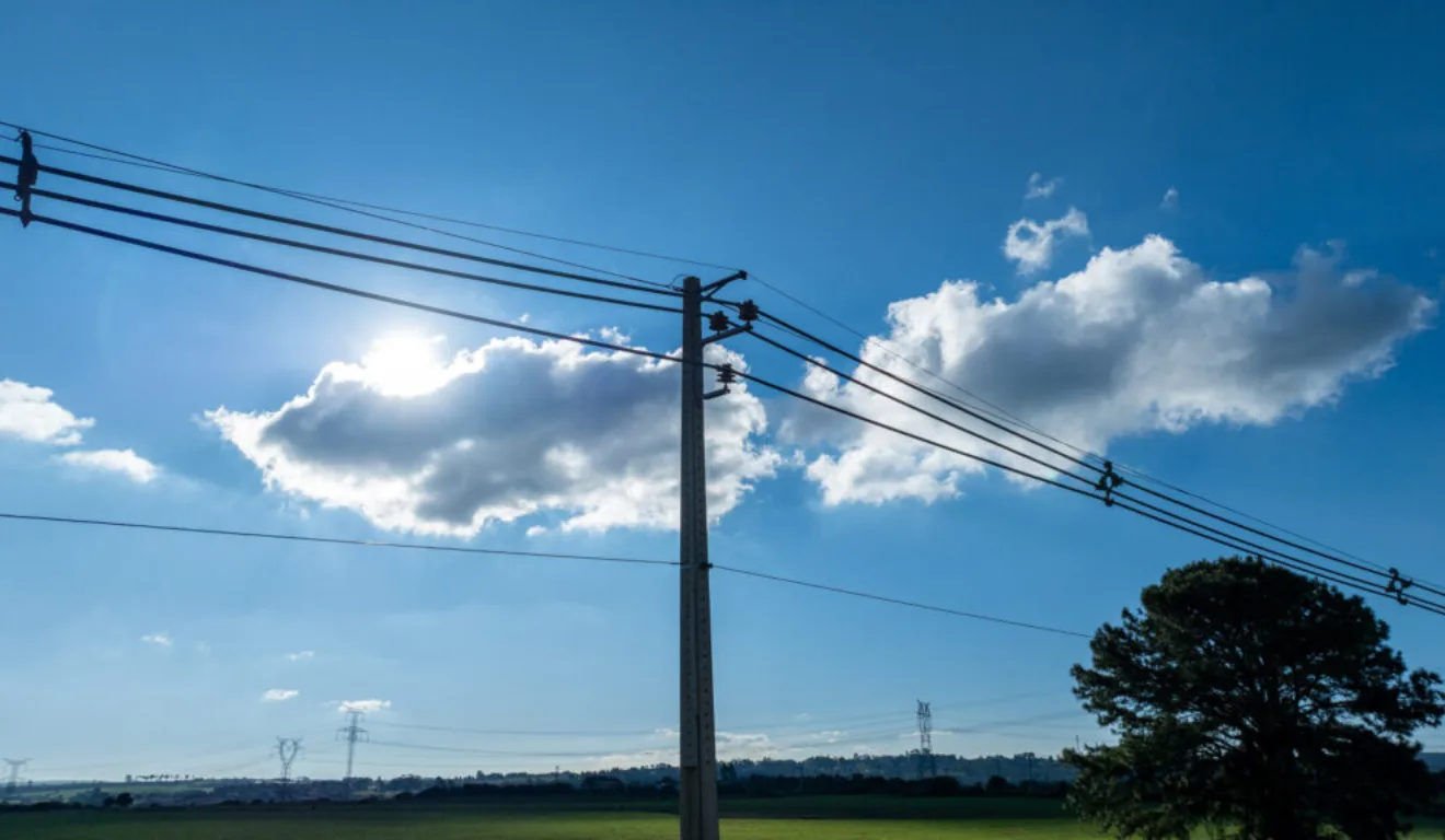 A imagem mostra um poste de energia elétrica com fios .