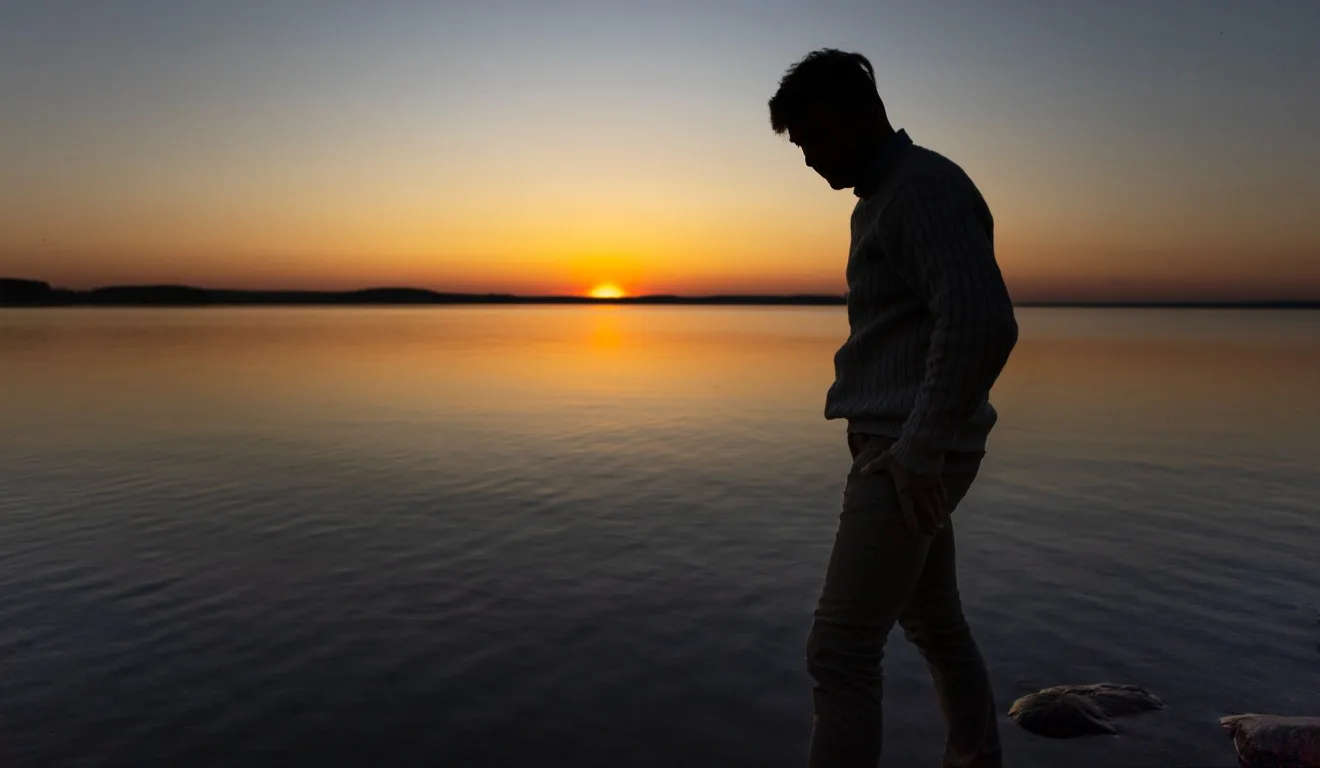 homem solitário em frente ao pôr-do-sol