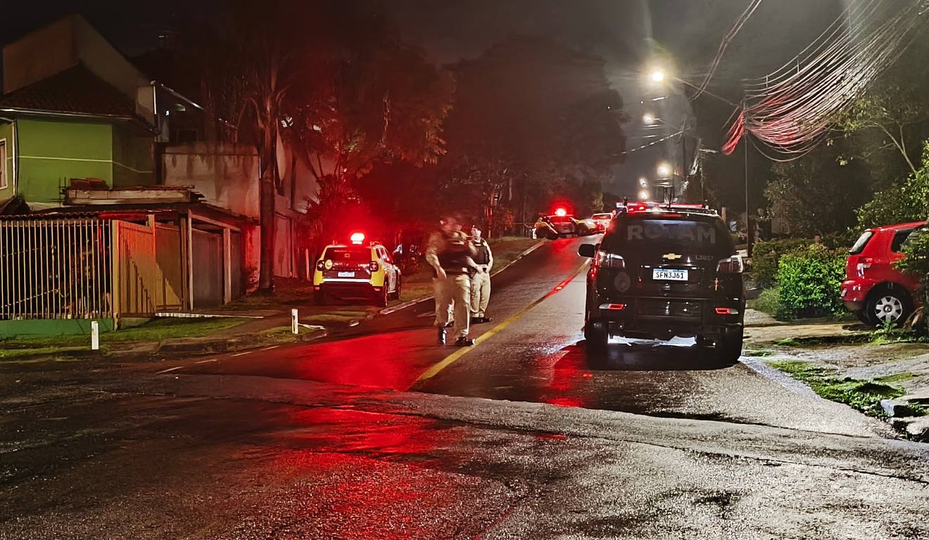 viaturas da PM em frente à casa de um homem de cerca de 40 anos, morto em confronto após ameaçar com u um revólver clientes de uma distribuidora de bebidas nas proximidades momentos antes, na Cidade Industrial de Curitiba