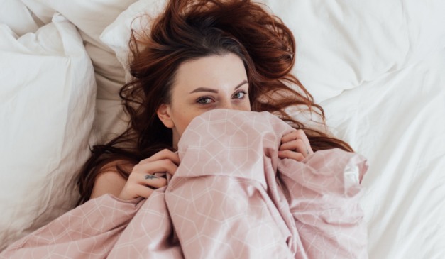mulher com cobertor no rosto