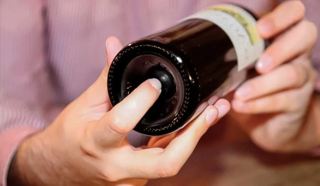 Mão no fundo da cavidade do vinho. 