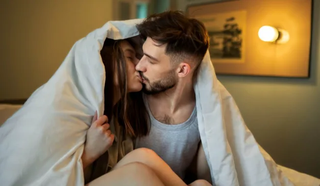 Casal se beijando em cama