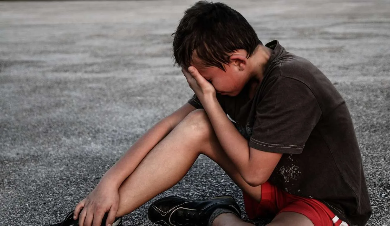 Adolescente chorando no asfalto