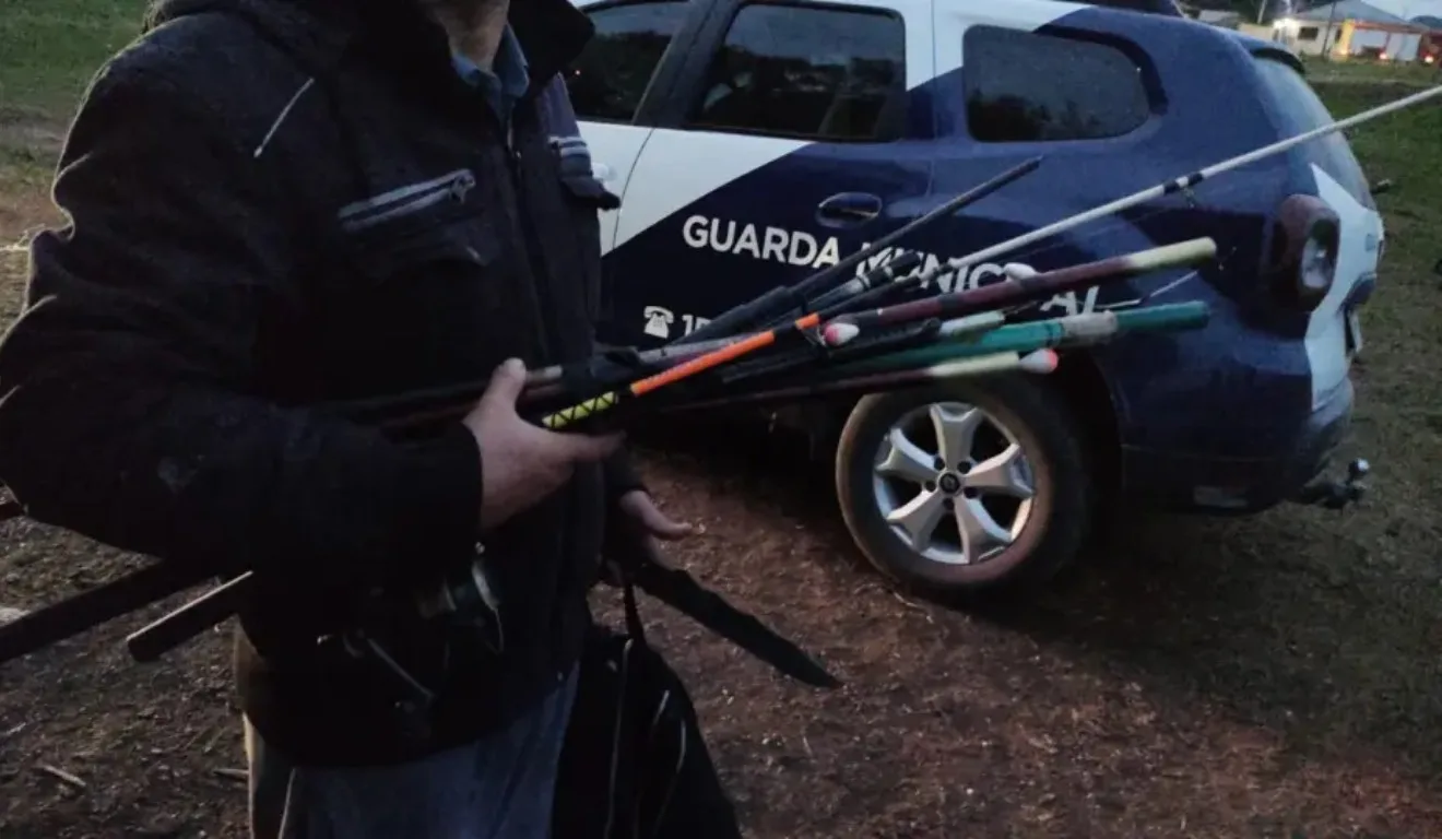 Guarda Municipal carregando varas de pesca