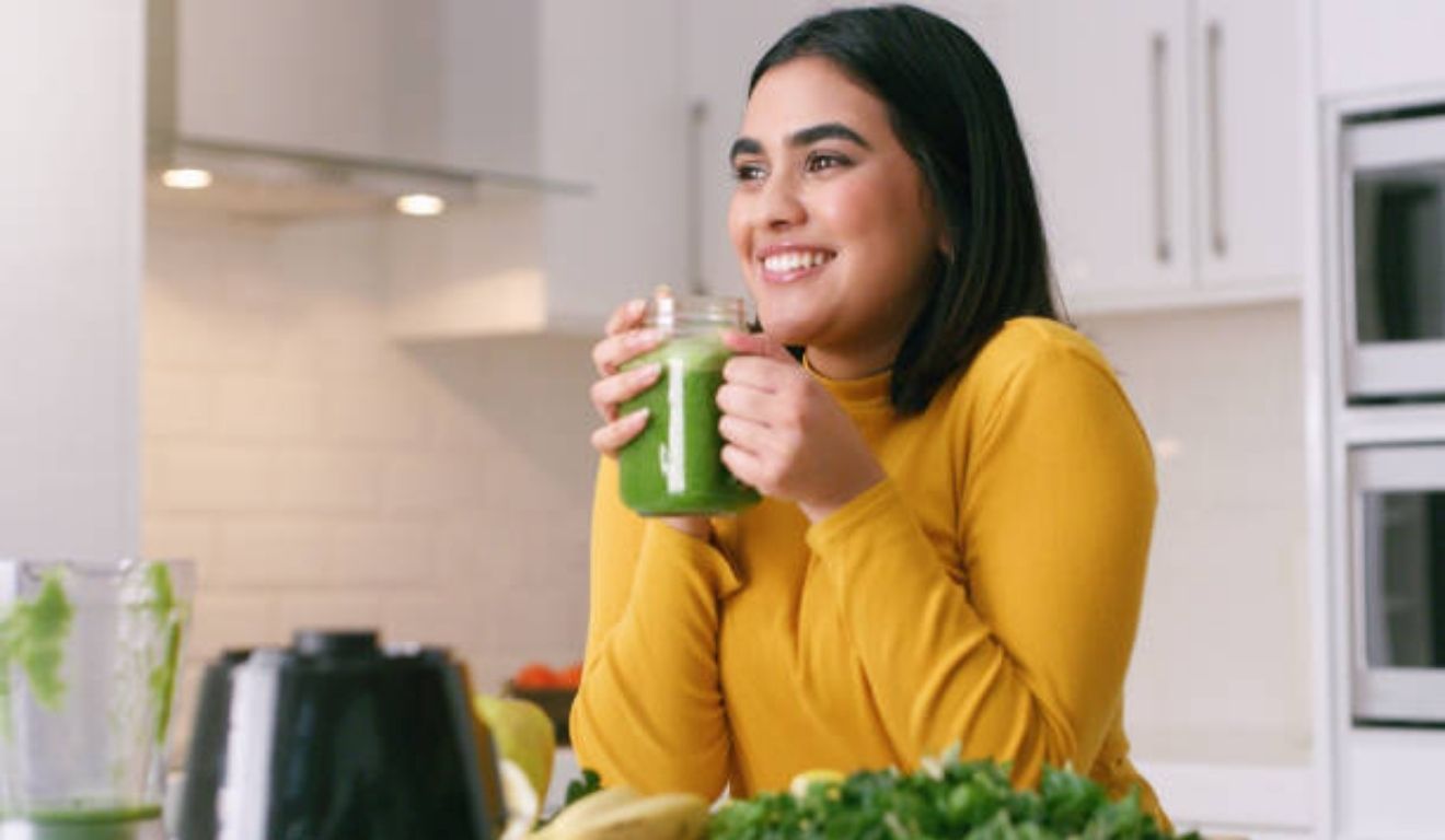 mulher tomando suco verde
