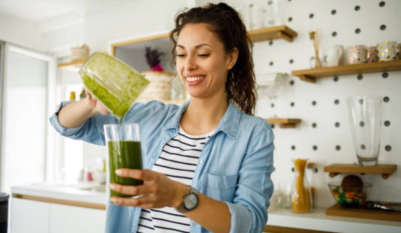 mulher tomando suco verde