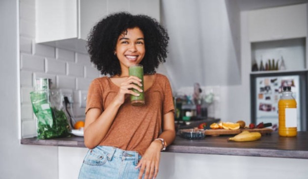 mulher tomando suco verde