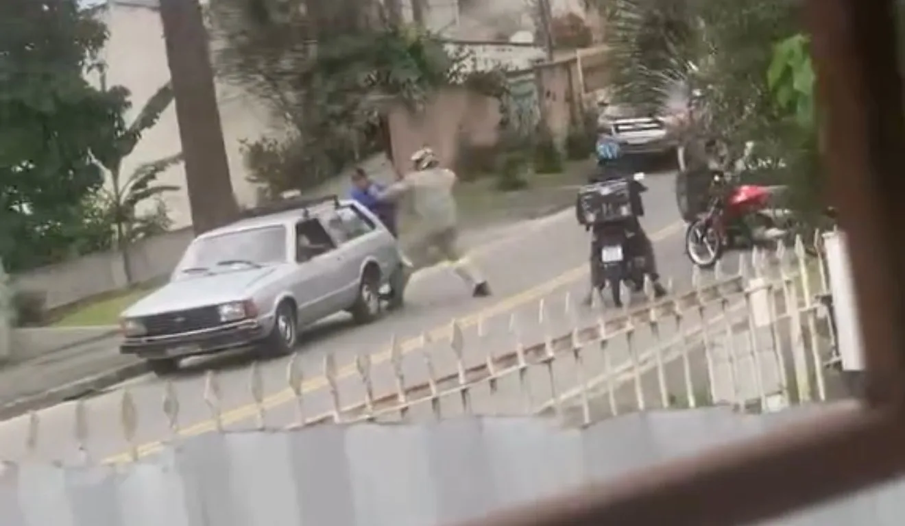 Motociclista desfere golpe de soco no rosto de idoso, que está ao lado de um carro 