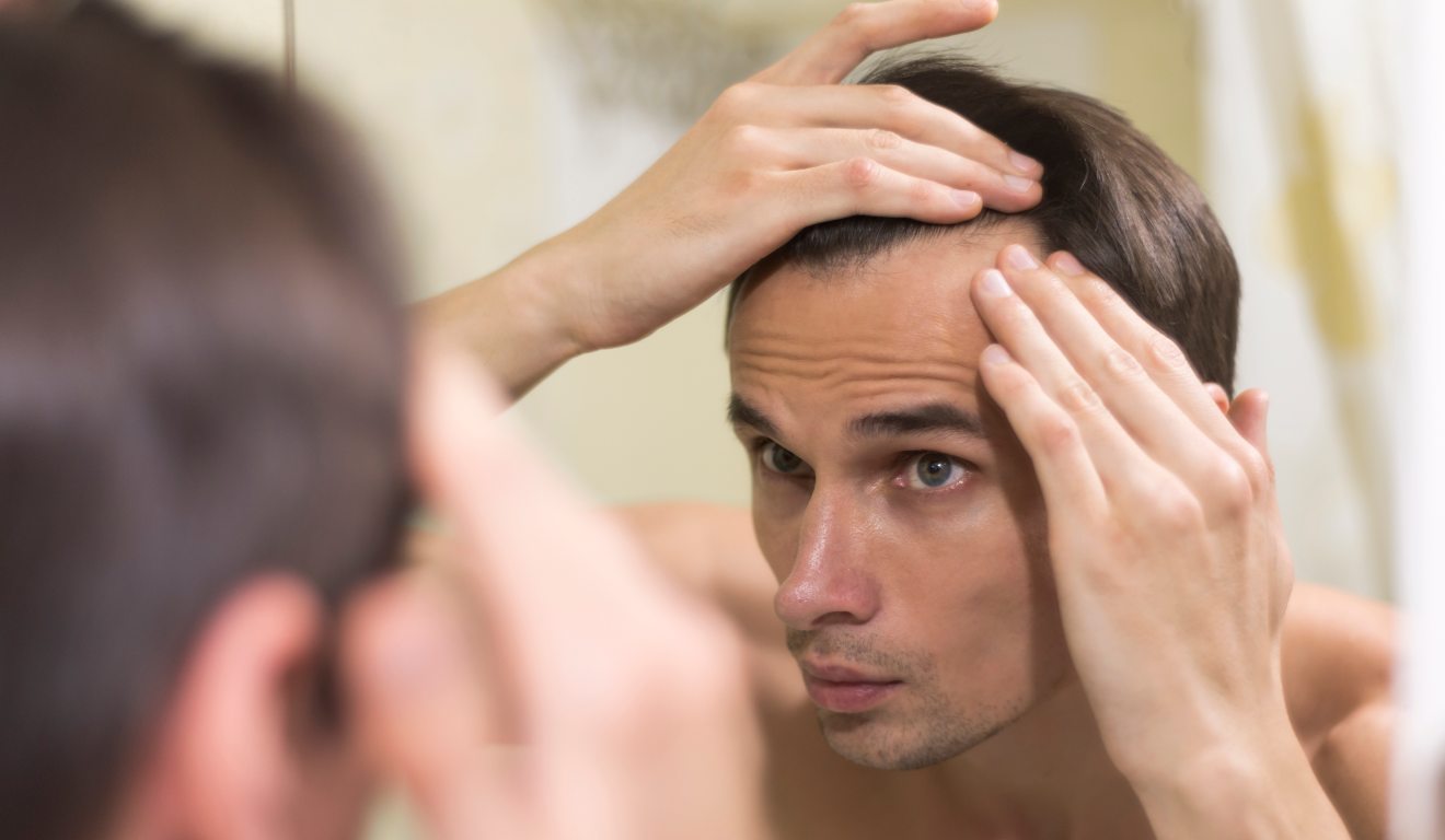 Jovem olhando o cabelo no espelho