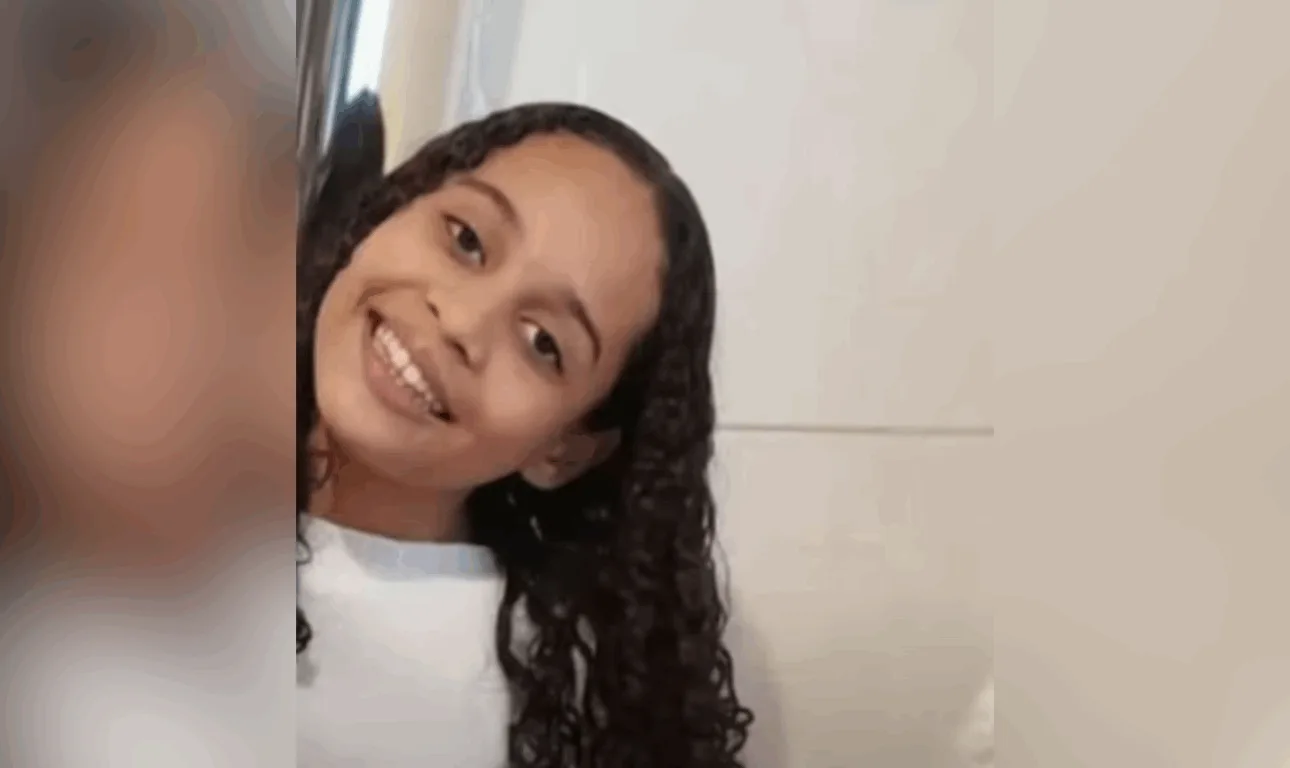 menina de cabelo cacheado sorrindo