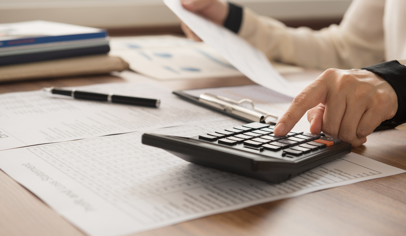 homem fazendo cálculos, com contas na mão e digitando na calculadora