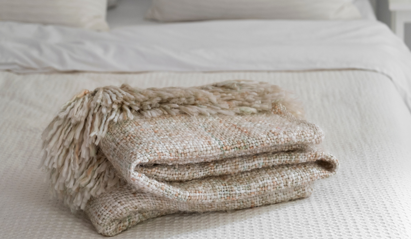 Imagem ilustrativa de uma cama com uma coberta por cima.