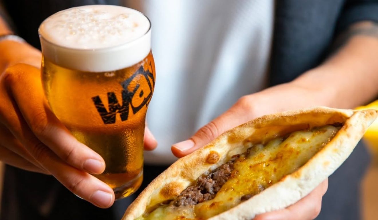 Cerveja e salgado nas mãos.