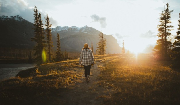 pessoa andando em meio às árvores para ilustrar o banho de floresta