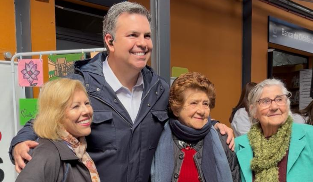 Imagem de Matheus Furlan abraçado com duas mulheres.