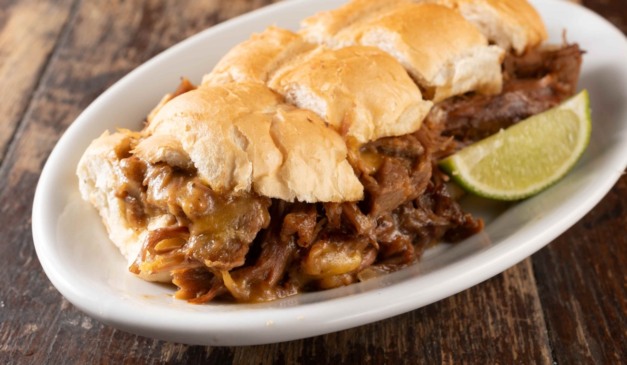 Sanduíche de carne desfiada com queijo, servido no pão francês, do cardápio de boteco em Curitiba.
