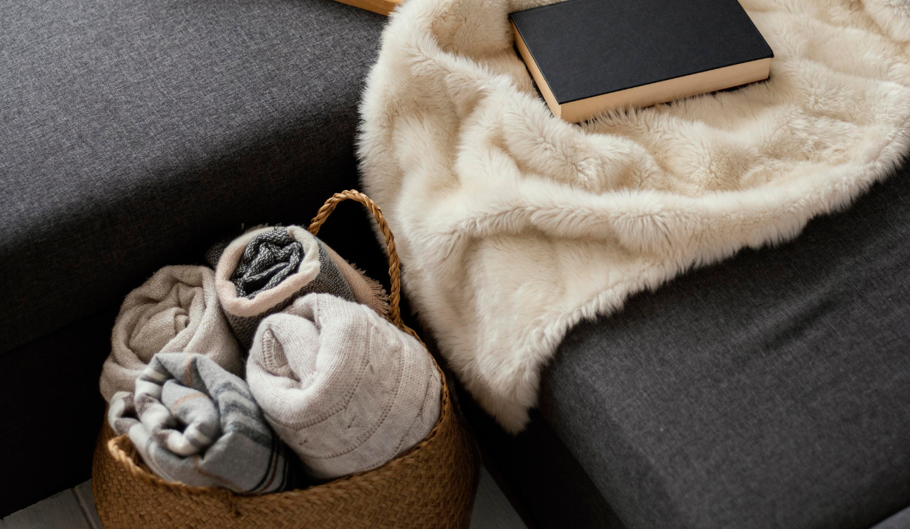 Imagem ilustrativa de um sofá com mantas e cobertores.