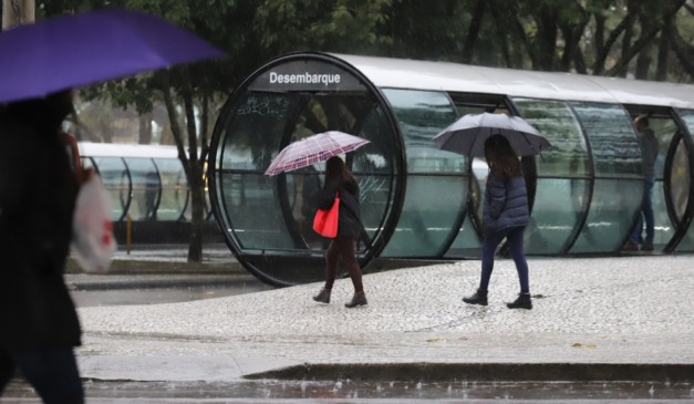 pessoas no centro da cidade em dia de chuva no Paraná