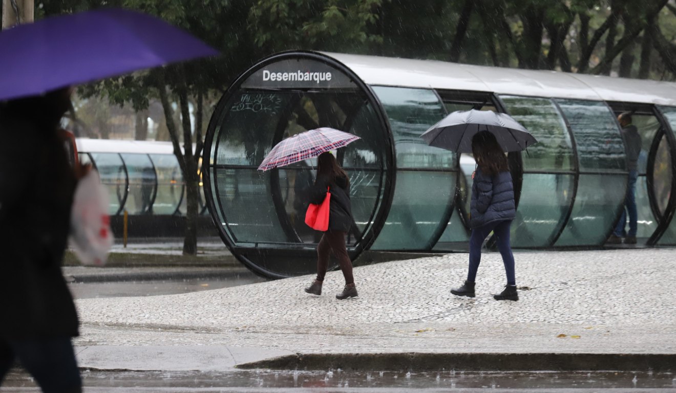 pessoas no centro da cidade em dia de chuva no Paraná