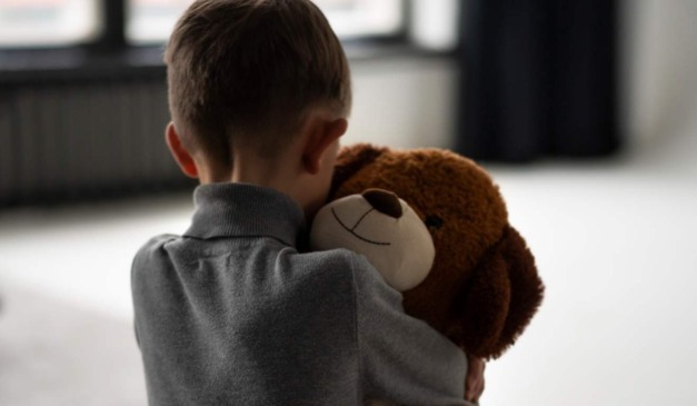 Criança abraçando um urso para representar criança abusada em igreja