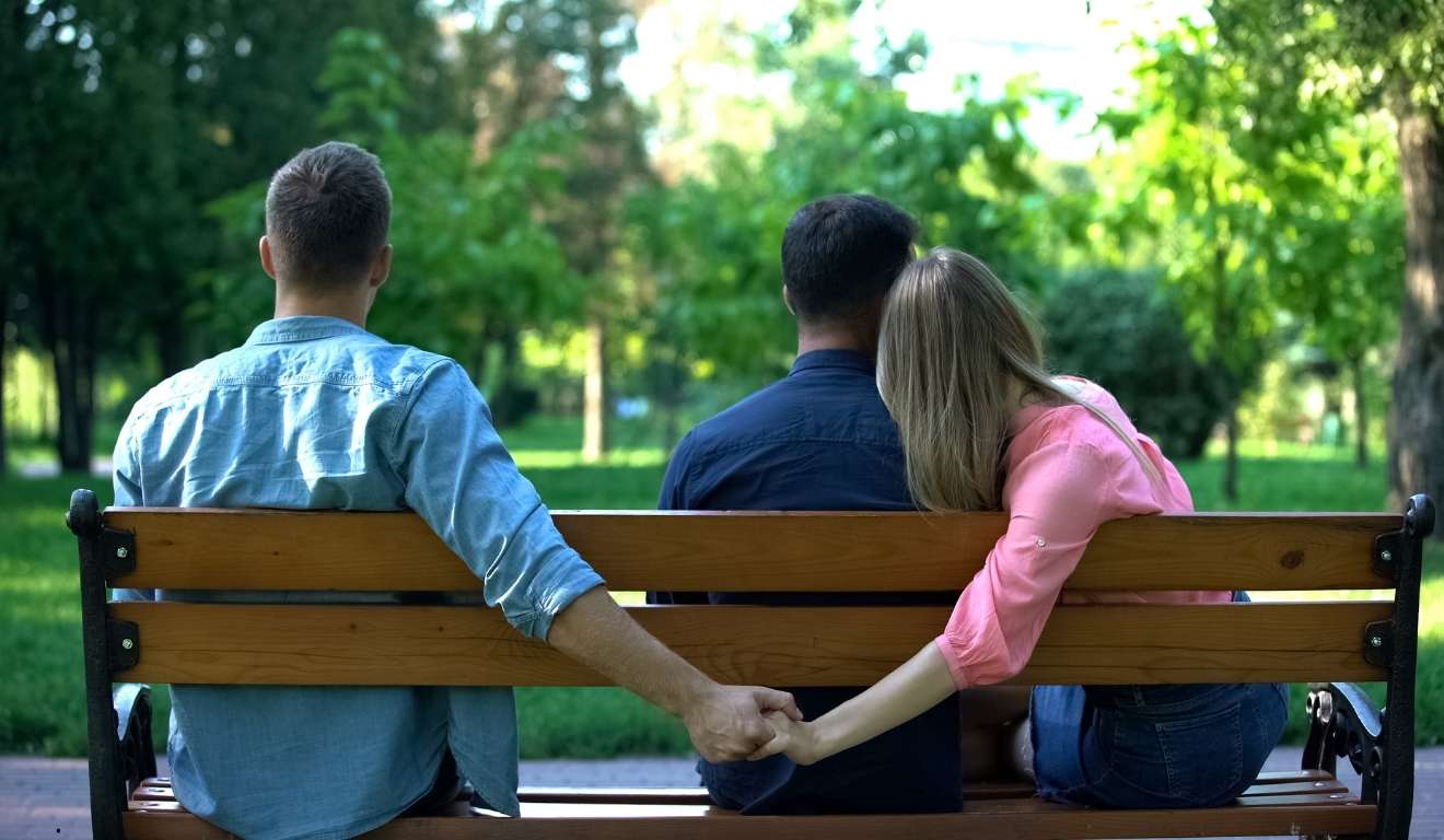 mulher de mãos dadas pro trás de outro homem