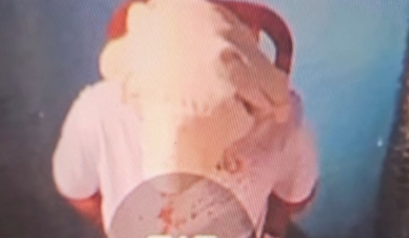 Homem com toalha sobre a cabeça aparece sentado e com as mãos amarradas para trás, simulando estar em cativeiro.

