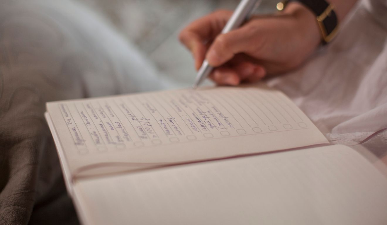 pessoas escrevendo em um livro para ilustrar o diário do sono