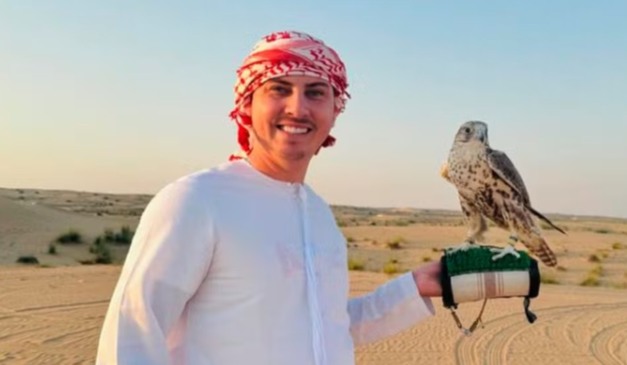 Eduardo Campelo com um gavião nas mãos, em pleno deserto árabe