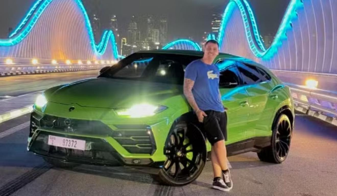 Influencer ao lado de um carro verde, em um ponto turístico de Dubai