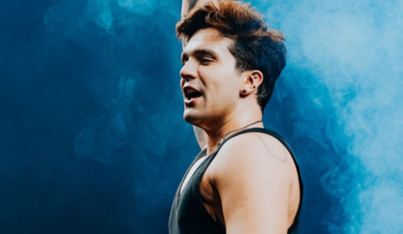 Luan santana com a m]ao para cima durante show