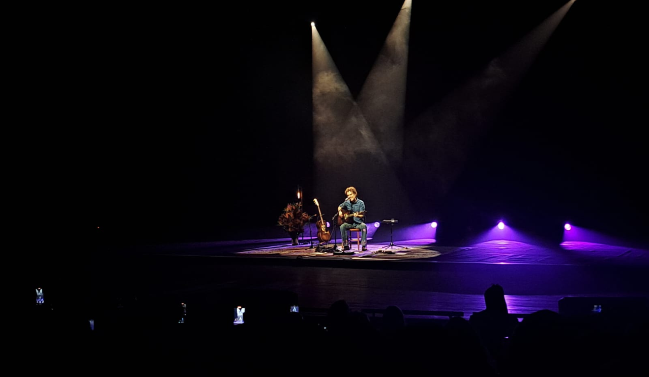 nando reis tocando no teatro guaíra durante show voz e violão