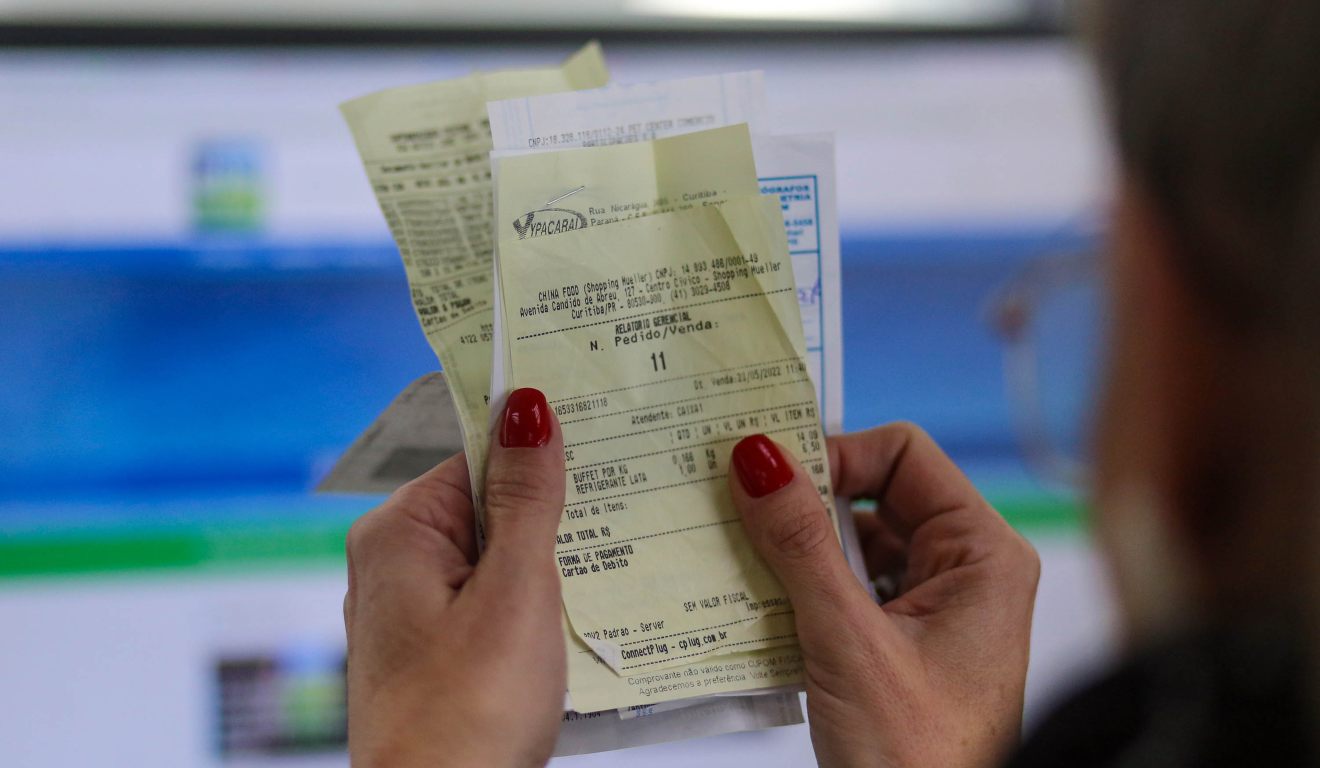 Mão segurando nota fiscal