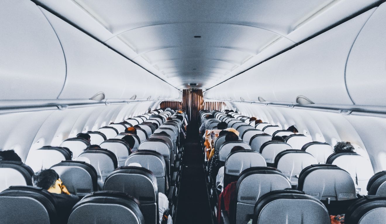 foto interna de um avião para ilustrar o caso de um passageiro que tentou abrir a porta de emergência