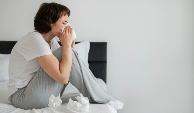 Pessoa com sinusite ou rinite assoando o nariz