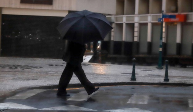 homem andando na chuva para ilustrar a previsão de temporal no paraná