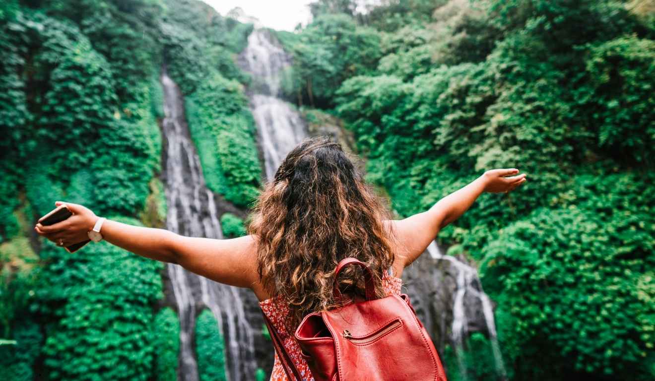 mulher em frente a cachoeira