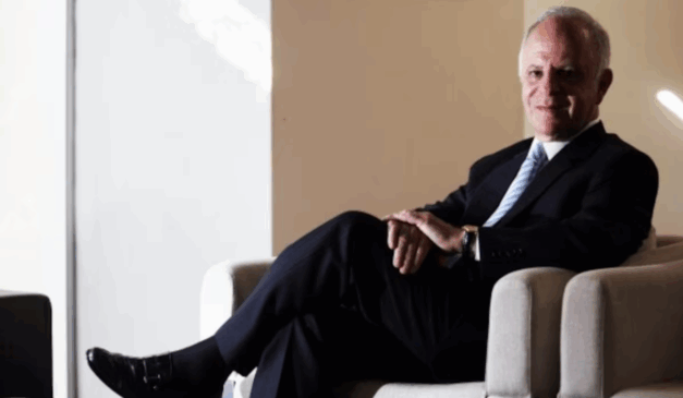 O oitavo homem mais rico do Brasil, Miguel Krigsner, é formado pela UFPR. Miguek é um homem branco, de cabelo grisalho, que usa um blazer preto, camisa branca, calça social preta e sapato preto.