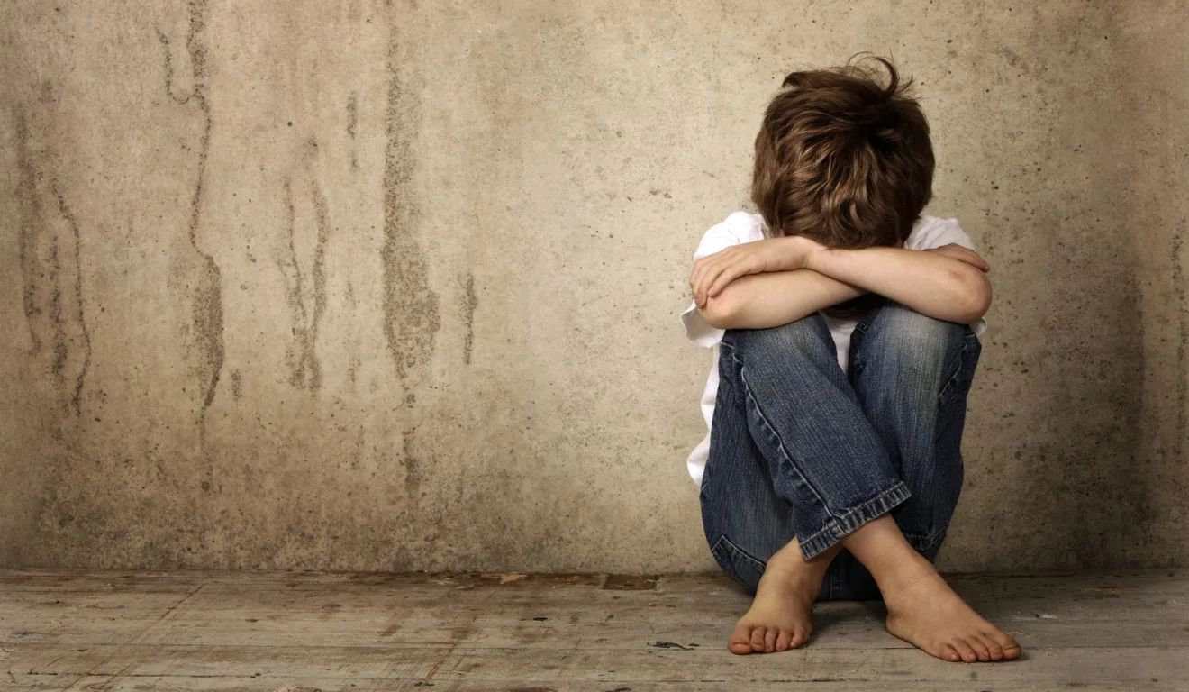 Imagem ilustrativa de criança com a cabeça entre as pernas; mães denunciaram casos de abusos e agressões em CMEI