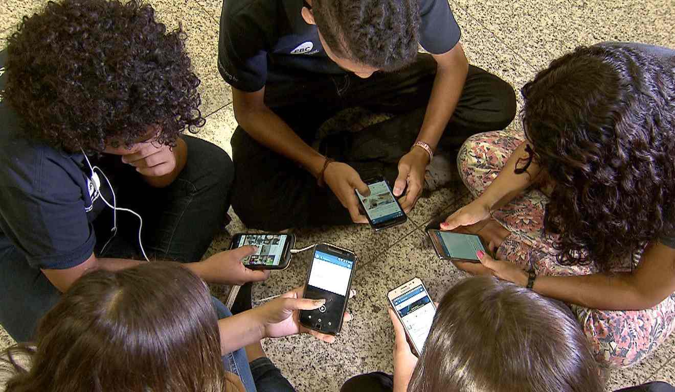 Crianças com celulares nas mãos