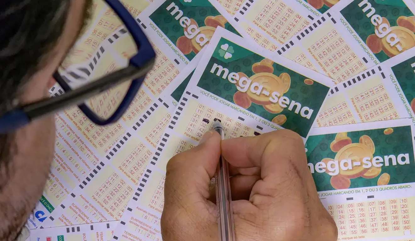 Homem assinando aposta da Mega-Sena