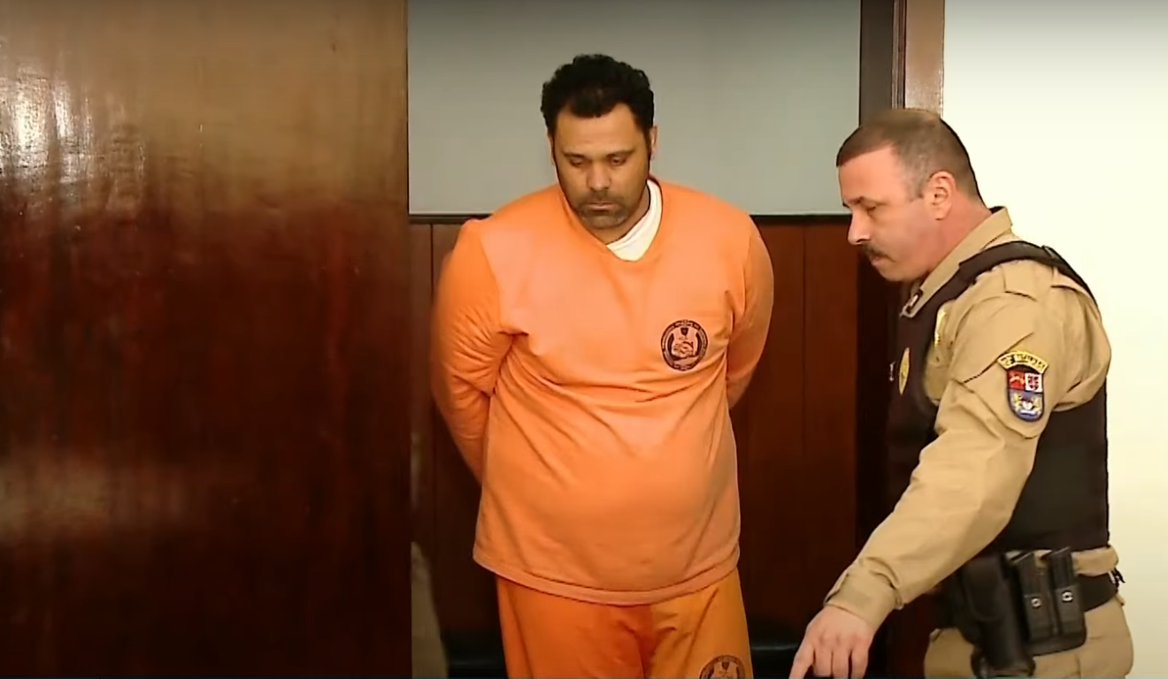 Marcelo Alves indo depor, depois de preso, com roupa laranja do presídio