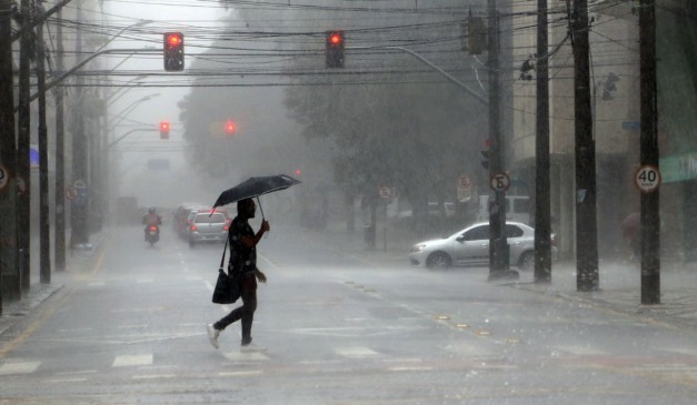 pessoa andando na chuva para ilustrar a chegada do ciclone no Paraná