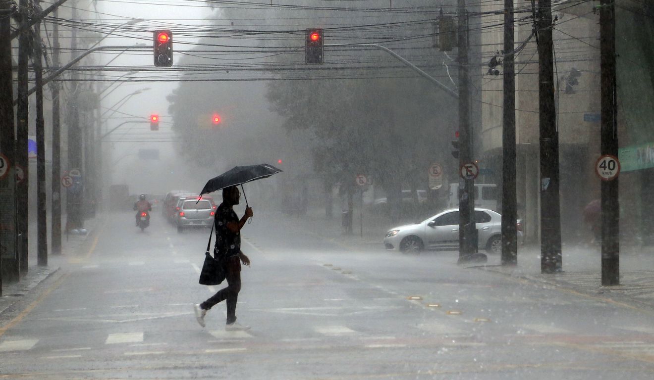 pessoa andando na chuva para ilustrar a chegada do ciclone no Paraná