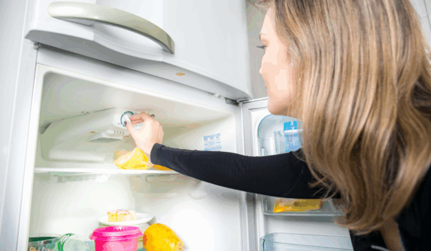 Mulher com geladeira aberta.