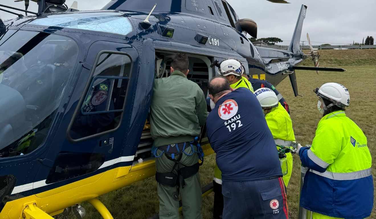 criança que caiu de caminhão em movimento sendo colocada em helicóptero