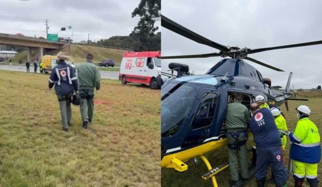 criança que caiu de caminhão em movimento sendo colocada em helicóptero