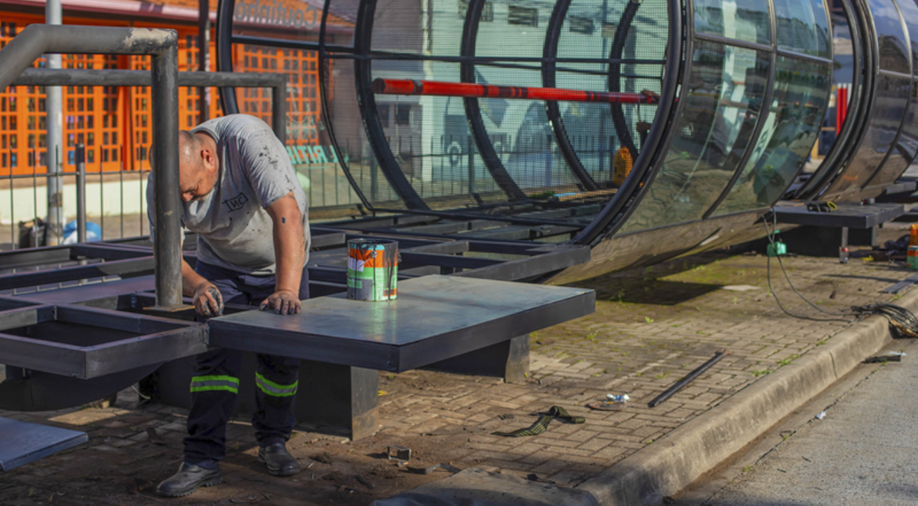 um trabalhador reformando a plataforma de descida de passageiros da estação-tubo