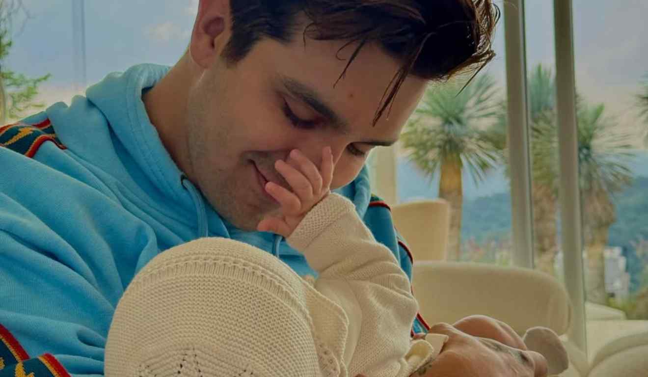 Luan Santana com a filha Serena fazendo carinho nele